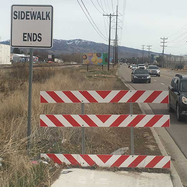 Sidewalk ends sign with blocked off sidewalk